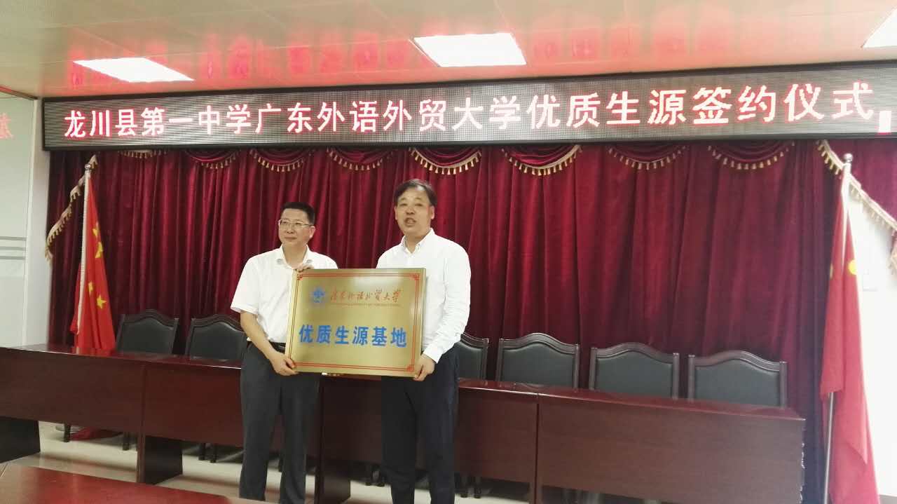杨魁向龙川县第一中学董事长吴志可颁授“优质生源基地”牌匾